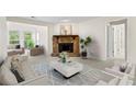 Cozy living room featuring a stone fireplace, complemented by abundant natural light from the surrounding windows at 1214 Lake Pointe Cir, Roswell, GA 30075