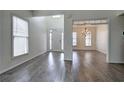 Open foyer boasts hardwood floors, natural light, and an elegant chandelier in the adjacent dining area at 233 Yorkshire Ln, Villa Rica, GA 30180