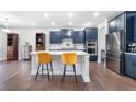 Modern kitchen with a large island, stylish seating, stainless steel appliances, and dark blue cabinetry at 411 Riverclub Rd, Acworth, GA 30101