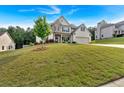 Two-story home sits on a lush green lawn with mature trees providing shade at 4575 Birch Way, Loganville, GA 30052