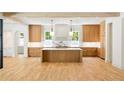 Bright kitchen boasts a large island, marble countertops, wooden cabinets and modern pendant lighting at 2515 Habersham Rd, Atlanta, GA 30305