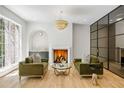 Cozy living room with fireplace, stylish light fixture, wet bar and views to a glass-enclosed area at 2515 Habersham Rd, Atlanta, GA 30305