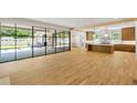 Open-concept living space with hardwood floors, leading to kitchen and outdoor patio through steel doors at 2515 Habersham Rd, Atlanta, GA 30305