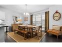 Bright dining room featuring a wooden table, chandelier, large windows, and modern decor at 1098 Caruso Dr, Buford, GA 30518