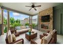 Relaxing covered patio with brick fireplace, TV, ceiling fan, and comfortable seating for outdoor enjoyment at 1112 Cordia Nw Ave, Atlanta, GA 30318