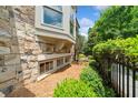 Serene side exterior featuring stone wall, bay window, and lush landscaping for enhanced privacy and appeal at 1112 Cordia Nw Ave, Atlanta, GA 30318