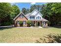 Charming two-story home with a manicured lawn, brick facade, black shutters, and inviting front porch at 2735 Princeton Trce, Cumming, GA 30041