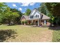 Charming two-story home with a manicured lawn, brick facade, black shutters, and inviting front porch at 2735 Princeton Trce, Cumming, GA 30041