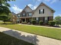 Attractive home with a manicured lawn and stone accents under a partly cloudy sky at 4316 Kershaw Dr, Snellville, GA 30039