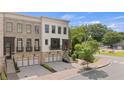 Inviting townhome showcasing brick and painted brick facade with a covered porch and attached garage at 210 Marjean Way, Alpharetta, GA 30009