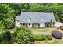 Traditional home with a manicured front yard, mature trees, and a brick walkway at 7660 Dunvegan Close, Sandy Springs, GA 30350