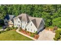 Beautiful two-story home with a well-maintained lawn, driveway, and classic architectural design at 3330 Arborwoods Dr, Alpharetta, GA 30022