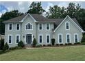 Elegant two-story house featuring symmetrical windows, stone steps, and a well-manicured lawn at 3330 Arborwoods Dr, Alpharetta, GA 30022