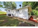 Exterior side view of a white home with a set of stairs and a view of the yard at 4682 Stonewall Tell Rd, College Park, GA 30349
