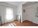 Bright room with light wood floors, large window with sheer curtains, modern decor, and white walls at 4682 Stonewall Tell Rd, College Park, GA 30349