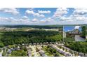 Expansive aerial view showcasing the community, mature trees, and the home, with mountain views in the distance at 5655 Hedge Brook Dr, Cumming, GA 30028