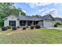 Charming single-story home with gray brick, manicured landscaping, and a two-car garage at 179 Carter Rd, Auburn, GA 30011
