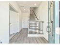 Bright foyer features wood-look floors, staircase with black metal railings, and plenty of natural light at 3313 Bartee Walk, Suwanee, GA 30024