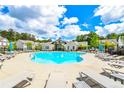 Community pool offers residents a refreshing oasis with plenty of lounge seating and blue umbrellas at 3313 Bartee Walk, Suwanee, GA 30024