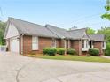 Side view of a brick home with a garage and a well-manicured lawn at 8117 Spivey Rd, Jonesboro, GA 30236