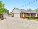 Side view of a brick home with a garage and a white picket fence at 8117 Spivey Rd, Jonesboro, GA 30236