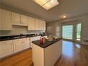 Bright kitchen with a center island, hardwood floors and a large bay window at 1301 Winesap Se Ct, Conyers, GA 30013