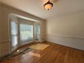 Sunlit room featuring a large bay window and pristine hardwood flooring for a welcoming space at 1301 Winesap Se Ct, Conyers, GA 30013