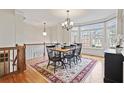Elegant dining room with hardwood floors, a chandelier, and a bay window overlooking the neighborhood at 1605 Pavillion Ridge Se Dr, Smyrna, GA 30080