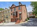 Charming three-story brick townhome with a two-car garage and bay window on a tree-lined street at 1605 Pavillion Ridge Se Dr, Smyrna, GA 30080
