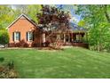Charming single-story brick home with a well-manicured lawn and mature landscaping in a serene setting at 3030 Heatherstone Dr, Cumming, GA 30041