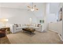 Spacious carpeted living room featuring high ceilings, a ceiling fan, and a comfortable sectional at 173 Kingswood Dr, Ellenwood, GA 30294