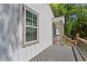 View of the side of the gray front porch with wood railing and a view of the white front door at 313 Yancy Se Dr, Marietta, GA 30067