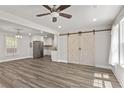 Open-concept living room featuring hardwood floors, barn doors and stainless steel appliances in the kitchen at 313 Yancy Se Dr, Marietta, GA 30067