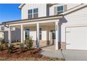 Inviting front entrance features a covered front porch with brick accents and a well landscaped yard at 5587 Rosehall Pl, Atlanta, GA 30349