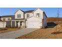 Charming two-story home features a covered front porch, a two car garage and professionally landscaped yard at 5587 Rosehall Pl, Atlanta, GA 30349