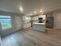 Bright kitchen featuring white cabinets, stainless steel appliances, granite countertops, and a convenient center island at 11045 Shadow Creek Ter, Hampton, GA 30228
