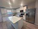 Modern kitchen equipped with stainless steel appliances, granite countertops, a central island, and ample cabinet space at 11045 Shadow Creek Ter, Hampton, GA 30228