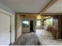 Renovation opportunity in a spacious living room with exposed ceiling beams and multiple windows at 1417 Richland Rd, Atlanta, GA 30310