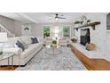 Bright living room featuring a decorative fireplace, hardwood floors, and neutral decor at 4615 Gresham Rd, Douglasville, GA 30134