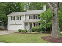 Traditional two-story home featuring a garage, green lawn, and mature tree at 120 Park Bridge Ln, Roswell, GA 30075