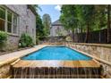 Outdoor pool with stone waterfall feature and patio area perfect for relaxation at 1720 Buckhead Valley Ne Ln, Atlanta, GA 30324