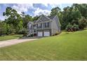 Beautiful two-story home with a manicured lawn and a two-car garage surrounded by lush trees at 20 Spruce Ne St, White, GA 30184