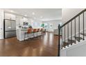 Open kitchen featuring a large island with bar stool seating and hardwood floors at 221 Begonia Way, Mcdonough, GA 30253