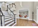 Grand foyer showcasing hardwood floors, a staircase with black handrails, and views into the living room at 3143 Denton Ne Pl, Roswell, GA 30075