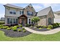 Attractive home with stone and gray wood facade, manicured landscaping, and a welcoming walkway at 320 Harvest View Ter, Woodstock, GA 30188