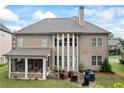 Two-story home with screened porch, backyard patio with fireplace and outdoor kitchen and spacious manicured lawn at 4769 Moon Hollow Ct, Buford, GA 30519