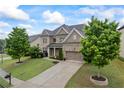 Two-story home with brick and siding exterior, manicured lawn, mature trees, and attached garage at 4769 Moon Hollow Ct, Buford, GA 30519