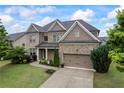 Charming two-story home features a brick facade, well-manicured lawn, and an attached two-car garage at 4769 Moon Hollow Ct, Buford, GA 30519