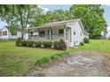 Well-maintained home with a covered front porch and gravel driveway surrounded by a green lawn at 6648 Florence Dr, Lithia Springs, GA 30122