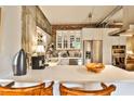 Bright kitchen with stainless steel appliances, white cabinetry, and exposed brick and concrete walls at 130 26Th St # 402, Atlanta, GA 30309